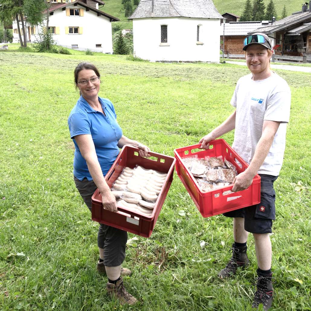 Frische Bio-Produkte vom eigenen Hof Frau und Mann tragen je eine Kiste mit frischen Bio-Produkten