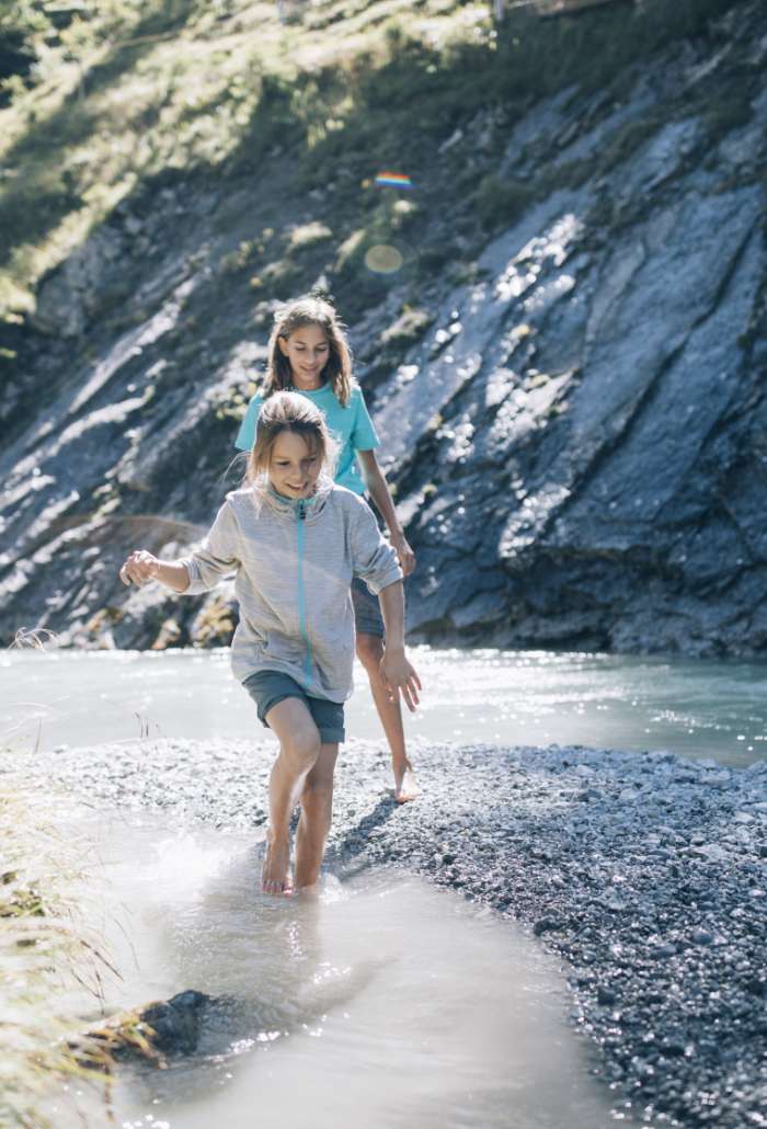 Sommer am Wasser Zwei Kinder laufen barfuß durch das flache Wasser