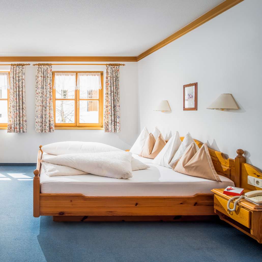 Doppelbett im hellen Vogelzimmer