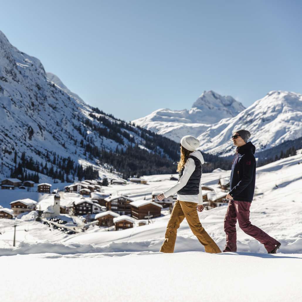 Winterwanderungen in Lech Zwei Personen wandern mit Blick auf das verschneite Tal in Lech